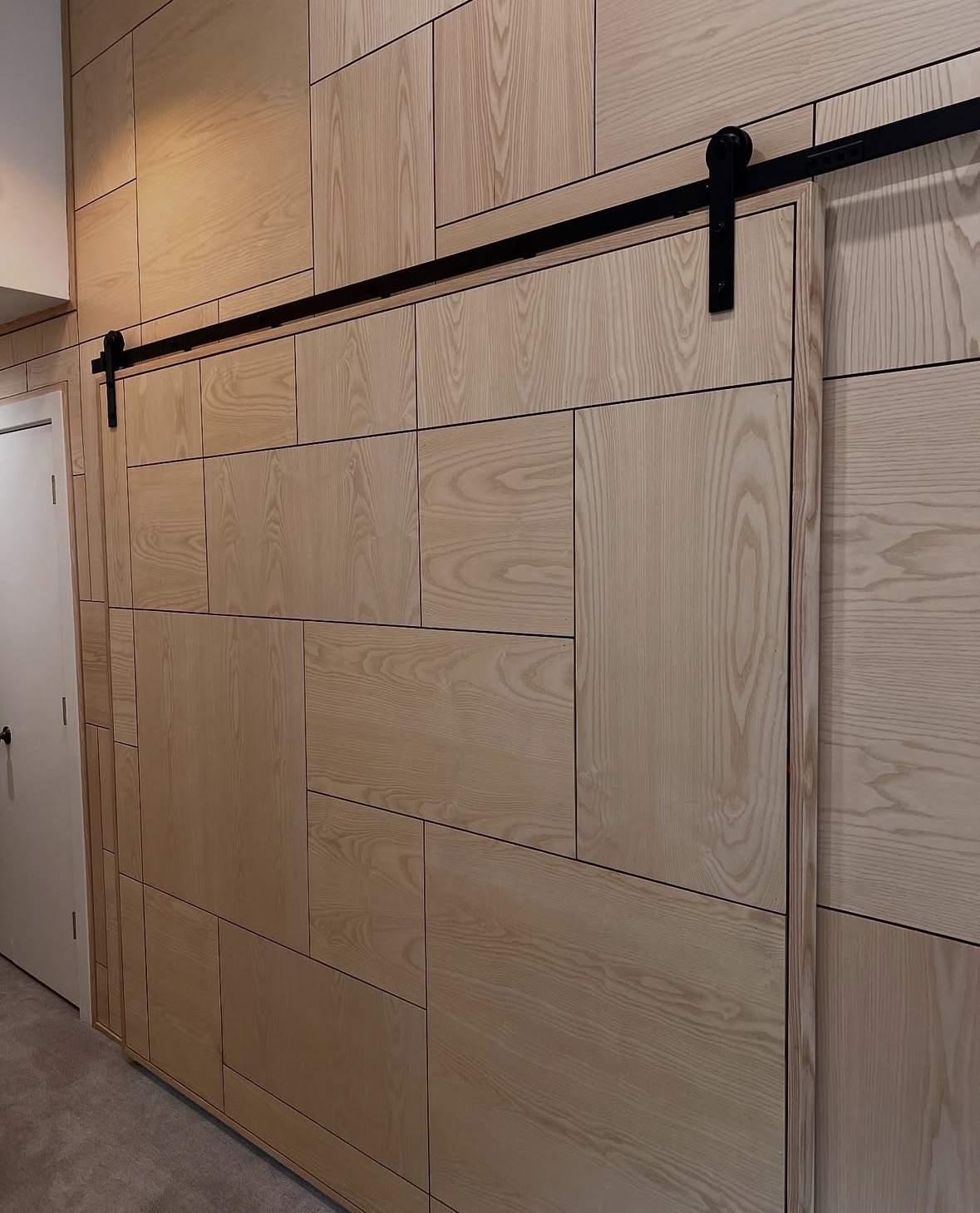 Geometric wood wall paneling and a matching sliding door