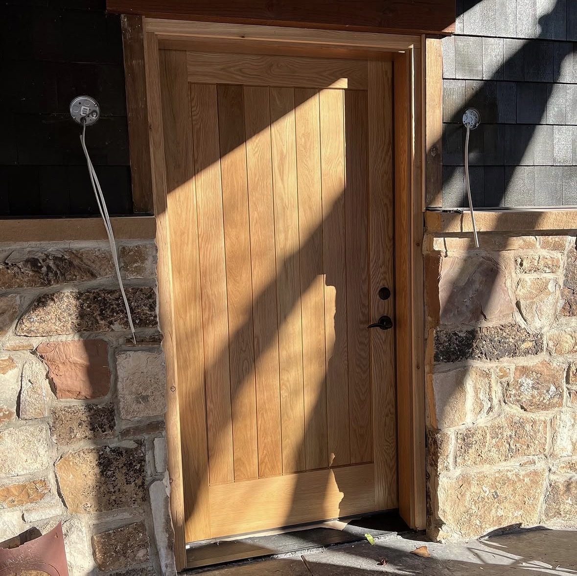 Natural white oak front door with stone surround