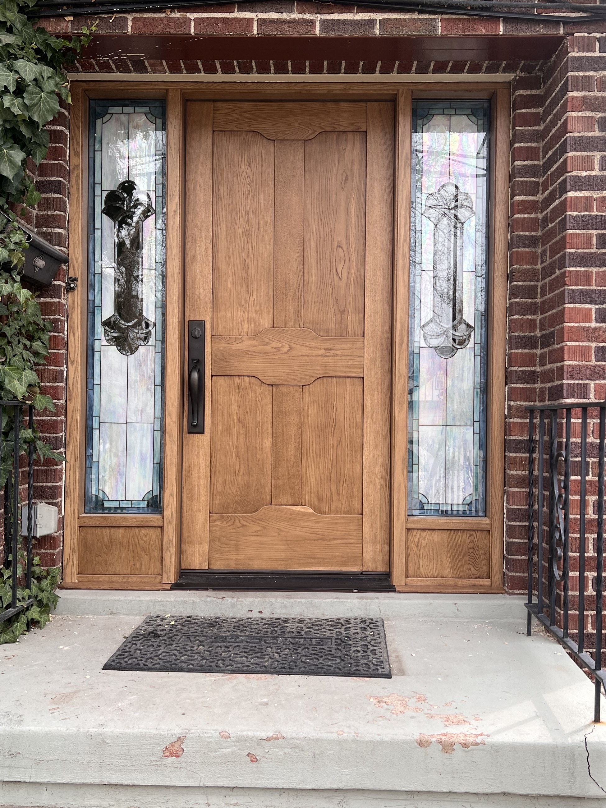 Closer view of the wood entry door and decorative glass sidelights